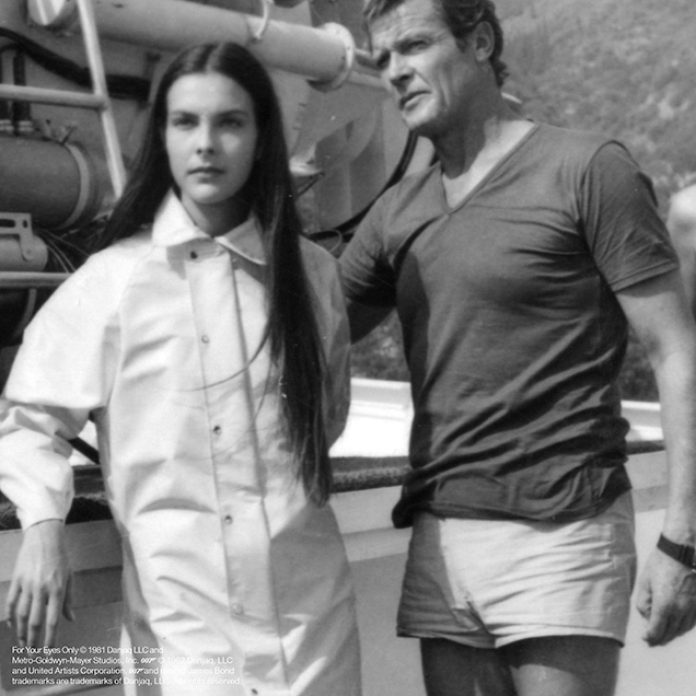 photo © Danjaq LLC, Metro-Goldwyn-Mayer Studios, Inc Roger Moore in a behind the scenes photo of For Your Eyes Only wearing a blue v-neck t-shirt and white shorts. The shorts are not seen in the film, he wears long trousers instead.